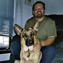 A man sitting on the floor with his dog.